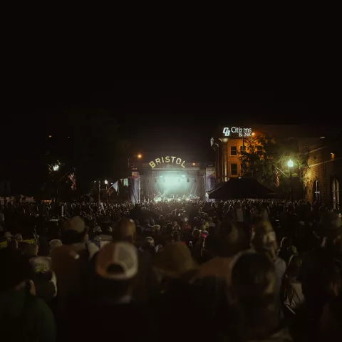 A large crowd of people enjoying a nighttime performance on State Street Stage at Bristol Rhythm & Roots Reunion.